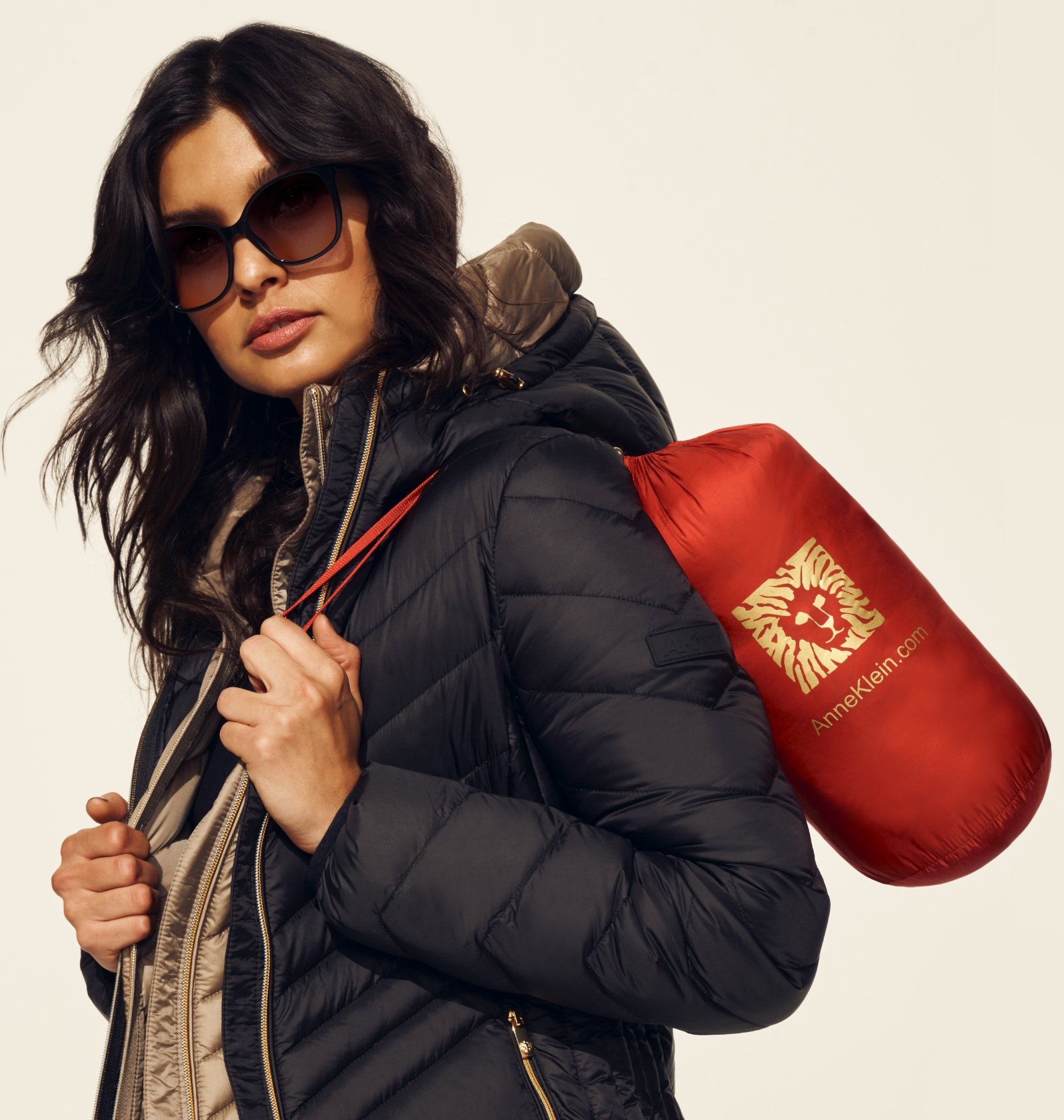 Anne Klein Model in Layered Puffers and sunglasses holding packable puffer