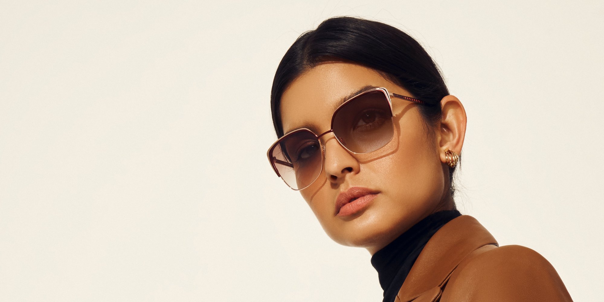 Anne Klein model in brown leather jacket and oversized sunglasses